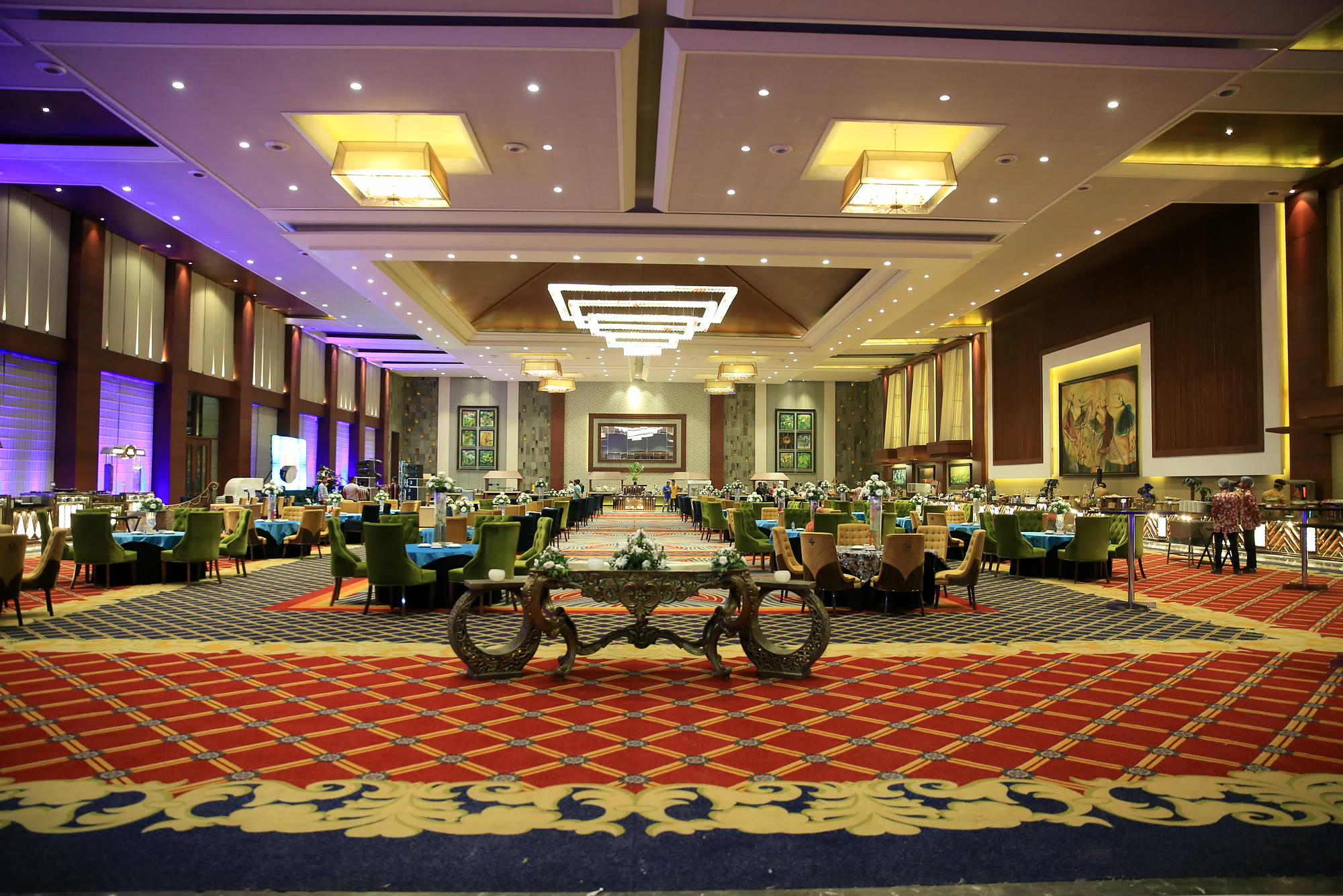 The Majestic Grand hall set for dinner: chandeliers, a red patterned carpet and tables running the full length of the room, with no pillars